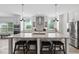 Modern kitchen with center island, bar stool seating, pendant lighting, and white cabinetry at 380 Perdues Rd, Louisburg, NC 27549