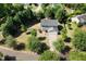 Aerial view of home with mature trees, fenced yard, and long driveway at 401 Onondaga Ct, Holly Springs, NC 27540