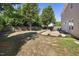 Spacious backyard featuring a patio area with a fire pit, landscaping, and mature trees at 401 Onondaga Ct, Holly Springs, NC 27540