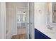 Bathroom with tub/shower combination with view into bedroom and navy blue vanity at 401 Onondaga Ct, Holly Springs, NC 27540