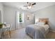 Cozy bedroom features a ceiling fan and a large window for natural light at 401 Onondaga Ct, Holly Springs, NC 27540