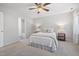 Bedroom with ceiling fan, neutral carpet, and ensuite bathroom access, flooded with natural light at 401 Onondaga Ct, Holly Springs, NC 27540