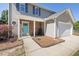 Close-up of house exterior featuring a teal front door and a cozy porch area at 401 Onondaga Ct, Holly Springs, NC 27540