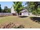 Well-maintained front yard featuring a lush lawn, mature trees, and a charming home exterior with a white garage door at 401 Onondaga Ct, Holly Springs, NC 27540