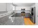 Well-lit kitchen with stainless steel appliances, granite counters, and white subway backsplash tiles at 401 Onondaga Ct, Holly Springs, NC 27540