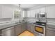 Kitchen with granite counters, stainless appliances and hardwood floors with a light-filled window at 401 Onondaga Ct, Holly Springs, NC 27540