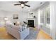 Bright living room features a fireplace, hardwood floors and a ceiling fan at 401 Onondaga Ct, Holly Springs, NC 27540