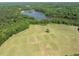 Aerial view of the expansive property and the bordering lake, surrounded by lush trees at 408 Blooming Meadows Rd, Holly Springs, NC 27540