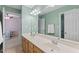 Bathroom featuring double sinks, wood cabinets, and neutral walls, with view to an adjacent bedroom at 408 Blooming Meadows Rd, Holly Springs, NC 27540