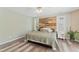 Stylish bedroom with a reclaimed wood accent wall, neutral tones, and abundant natural light at 408 Blooming Meadows Rd, Holly Springs, NC 27540