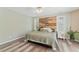 Spacious bedroom featuring a wood accent wall, large windows, and wood-look flooring at 408 Blooming Meadows Rd, Holly Springs, NC 27540