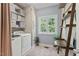 Functional laundry room with washer, dryer, shelving, and natural light at 408 Blooming Meadows Rd, Holly Springs, NC 27540