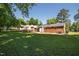 Large backyard with lush green grass, mature trees, and a view of the rear exterior of the brick home at 430 Fenton St, Raleigh, NC 27604