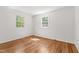 Bedroom featuring hardwood floors, white walls, and natural light from two windows at 430 Fenton St, Raleigh, NC 27604