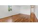 Bright room featuring hardwood floors, white walls, a window, and a white door at 430 Fenton St, Raleigh, NC 27604