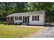 Charming single-story home with white siding, black shutters, brick accents, and landscaped front yard at 430 Fenton St, Raleigh, NC 27604