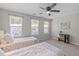 Bedroom with two twin beds, ceiling fan, two windows, and a desk with chair in the corner at 4535 Sugarbend Way, Raleigh, NC 27606