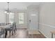 Bright dining area featuring hardwood floors, a chandelier, and a view of the front door at 4535 Sugarbend Way, Raleigh, NC 27606