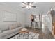 Comfortable living room with wood floors, a sofa, and an open layout to the kitchen at 4535 Sugarbend Way, Raleigh, NC 27606