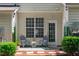 Covered patio with two chairs and a small table with plants and a decorative green wall at 4535 Sugarbend Way, Raleigh, NC 27606