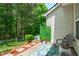 Charming patio area with seating and decorative plants and a view of the wooded back yard at 4535 Sugarbend Way, Raleigh, NC 27606