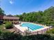 Community pool surrounded by trees and lounge chairs at 4535 Sugarbend Way, Raleigh, NC 27606