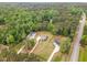 Aerial view of the property showcasing lush greenery, a pond, and neighboring homes in a wooded setting at 46 Bonterra Way, Chapel Hill, NC 27516