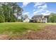 Expansive backyard with a well-manicured lawn, mature trees, and a view of the home's screened porch at 46 Bonterra Way, Chapel Hill, NC 27516