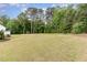 Vast backyard featuring a lush lawn and mature trees, providing a private and serene outdoor space at 46 Bonterra Way, Chapel Hill, NC 27516