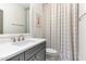 Neutral bathroom featuring a vanity with gray cabinets, a white countertop and a patterned shower curtain at 46 Bonterra Way, Chapel Hill, NC 27516