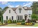Charming home featuring a painted brick facade, dormer windows, and a professionally landscaped front yard at 46 Bonterra Way, Chapel Hill, NC 27516