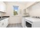 Bright laundry room with black and white patterned floors, white cabinets and a window at 46 Bonterra Way, Chapel Hill, NC 27516
