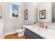 Stylish powder room with gray vanity, marble countertop, and a window bringing in natural light at 46 Bonterra Way, Chapel Hill, NC 27516