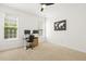 Bright bedroom featuring neutral carpet, white walls, ceiling fan, and two large windows at 5213 Holly Ridge Farm Rd, Raleigh, NC 27616