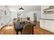 Dining room with hardwood floors flowing into the living area with modern decor and bright lighting at 5213 Holly Ridge Farm Rd, Raleigh, NC 27616