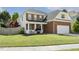 Charming two-story home with a partial brick facade, well-manicured lawn, and inviting front porch at 5213 Holly Ridge Farm Rd, Raleigh, NC 27616
