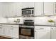 Close up of a well-equipped kitchen with stainless steel appliances and white cabinetry at 5213 Holly Ridge Farm Rd, Raleigh, NC 27616