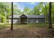 View of the back of the house showcasing the large back deck, backyard, and back door entry at 5402 Shealtiel Way, Rougemont, NC 27572