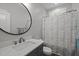 Bathroom with a round mirror and a shower featuring a patterned curtain, combining style and functionality at 5402 Shealtiel Way, Rougemont, NC 27572