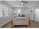 Bright bedroom with a ceiling fan, wood floors, and ample natural light from the large windows at 5402 Shealtiel Way, Rougemont, NC 27572