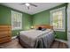 Bedroom with green walls, wood floors, and a double window, providing a peaceful and refreshing atmosphere at 5402 Shealtiel Way, Rougemont, NC 27572