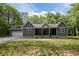 Charming exterior of a gray home featuring a covered porch and an attached garage at 5402 Shealtiel Way, Rougemont, NC 27572