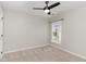 Minimalist bedroom with neutral carpet, ceiling fan and a large window at 5504 Creekdale Cir, Raleigh, NC 27612