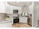 Modern kitchen featuring white cabinets, granite countertops, and stainless steel appliances at 5504 Creekdale Cir, Raleigh, NC 27612