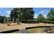 Community playground with slides and climbing equipment surrounded by mature trees and a wood chip ground covering at 5504 Creekdale Cir, Raleigh, NC 27612