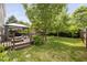 Lush backyard featuring a deck with outdoor seating, a charming playhouse, and a well-manicured lawn at 5512 Bridgeman Ct, Durham, NC 27703