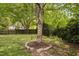 Backyard featuring green grass, a wooden fence, mature trees, and a rope swing at 5512 Bridgeman Ct, Durham, NC 27703