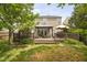 An outdoor wood deck with furniture, an umbrella, and a grill is attached to the home with a large yard at 5512 Bridgeman Ct, Durham, NC 27703