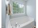 Relaxing bathtub with a window view, chrome fixtures, and a towel rack, creating a spa-like ambiance at 5512 Bridgeman Ct, Durham, NC 27703