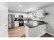 Updated kitchen boasts stainless steel appliances, white cabinets, and a breakfast bar at 5512 Bridgeman Ct, Durham, NC 27703